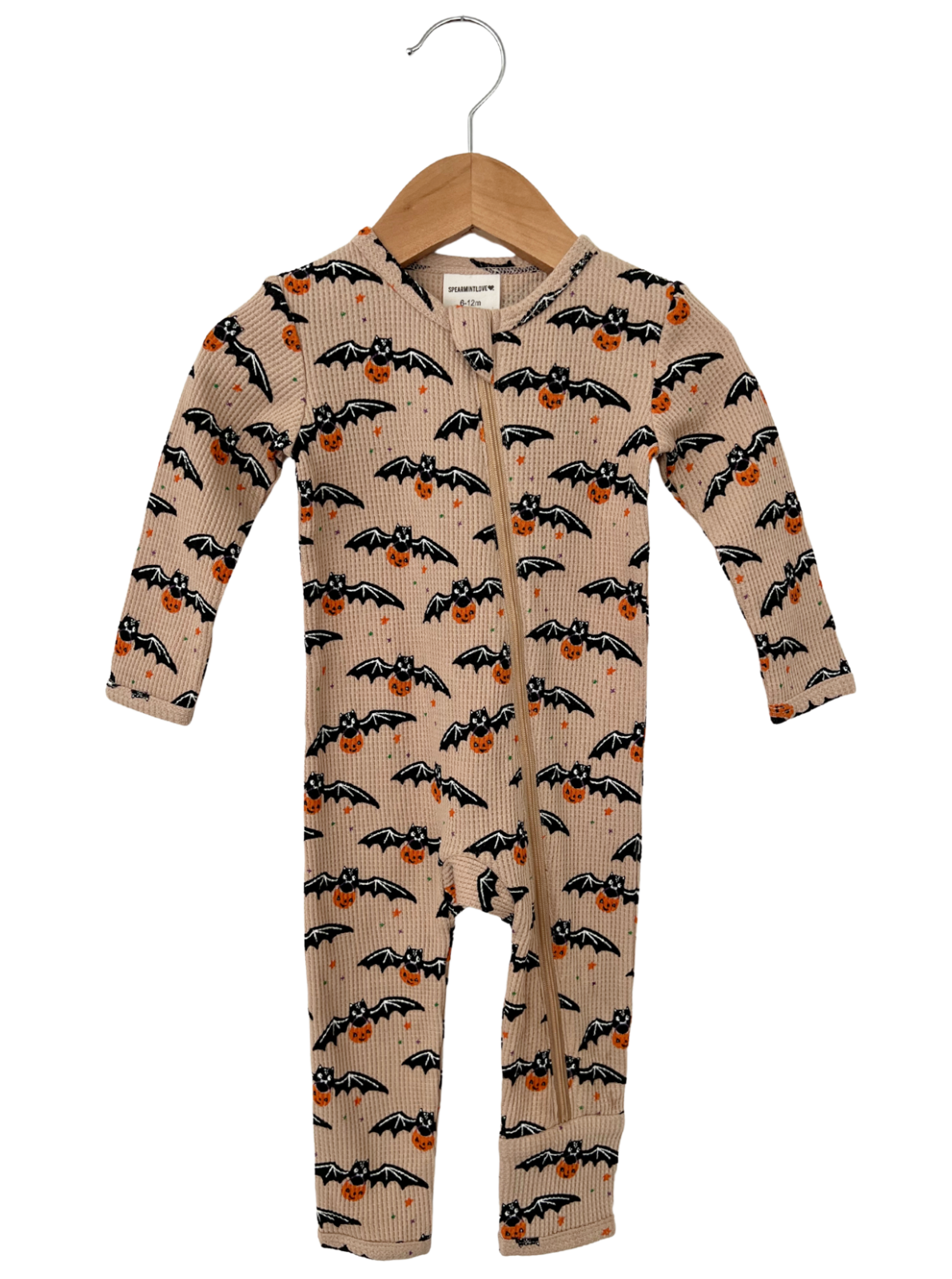 Infant onesie with bat and pumpkin print, featuring a hood and zipper, hanging on a wooden hanger.