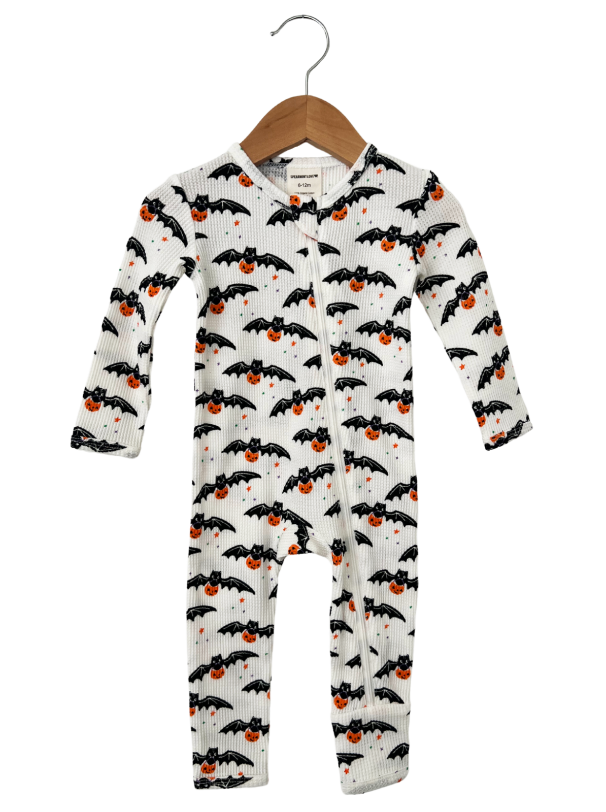Baby onesie with bat and pumpkin pattern, hanging on a wooden hanger, suitable for Halloween.