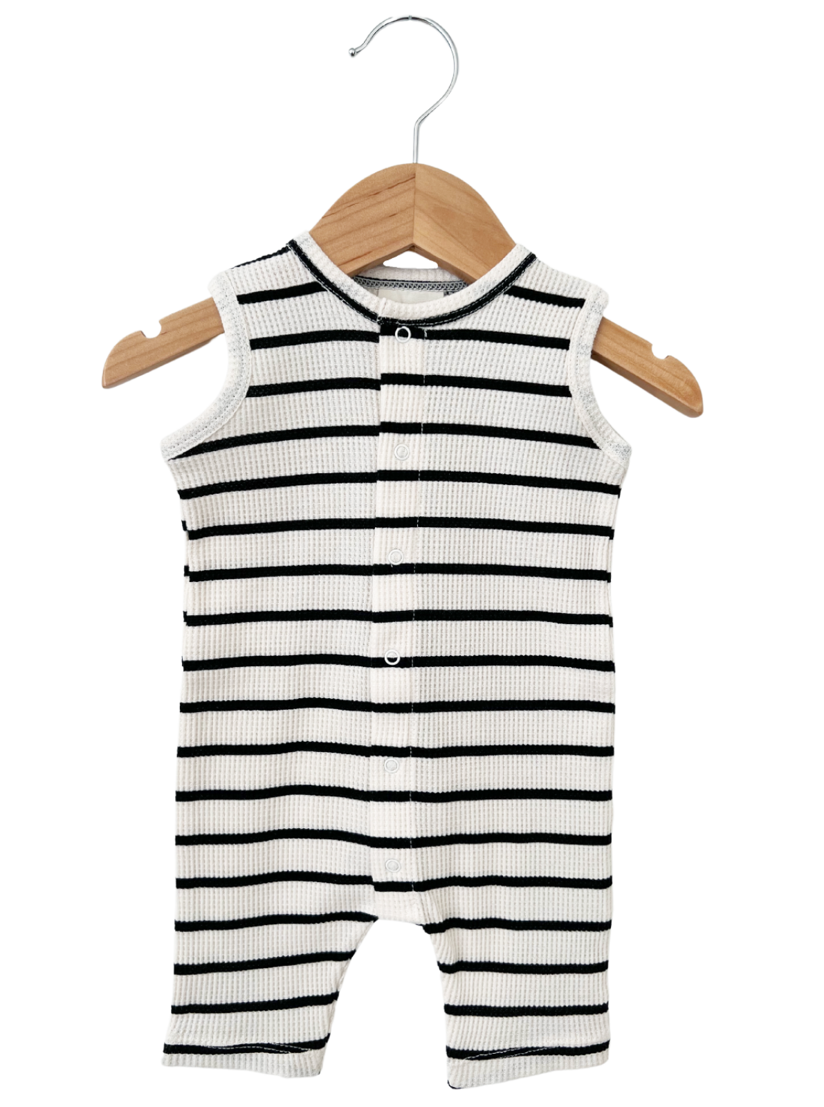 Black and white striped infant onesie hanging on a wooden hanger.