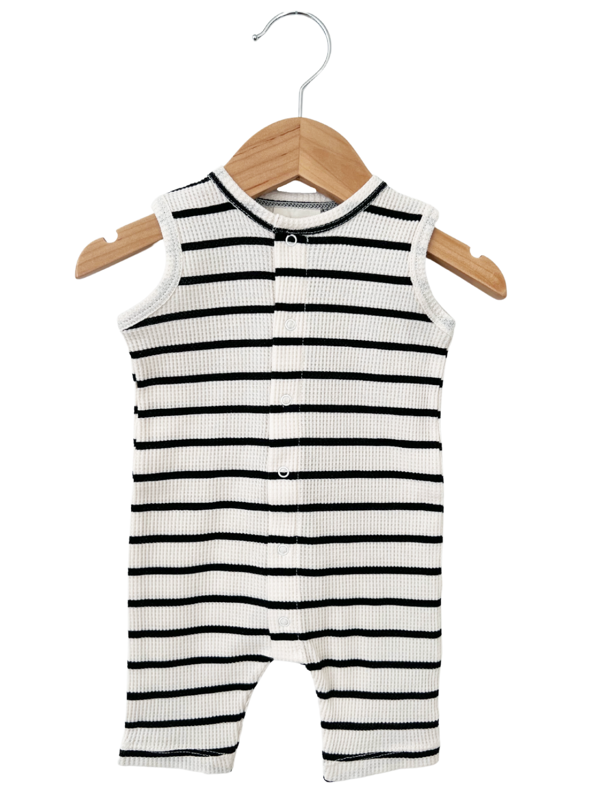 Black and white striped infant onesie hanging on a wooden hanger.