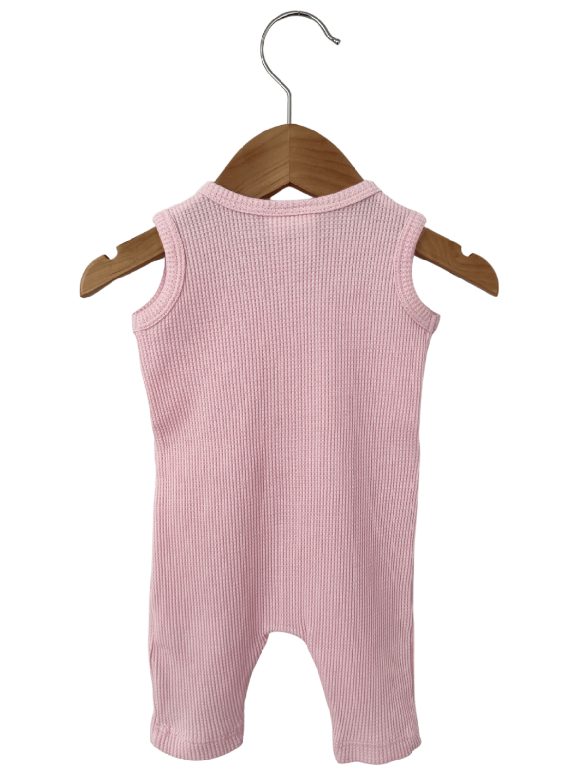 Pink ribbed onesie hanging on a wooden hanger against a white background.