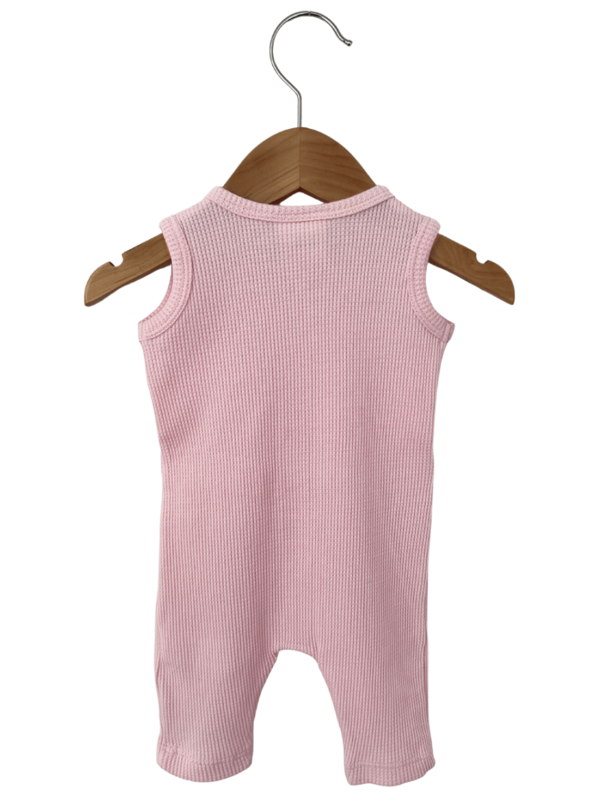 Pink ribbed onesie hanging on a wooden hanger against a white background.