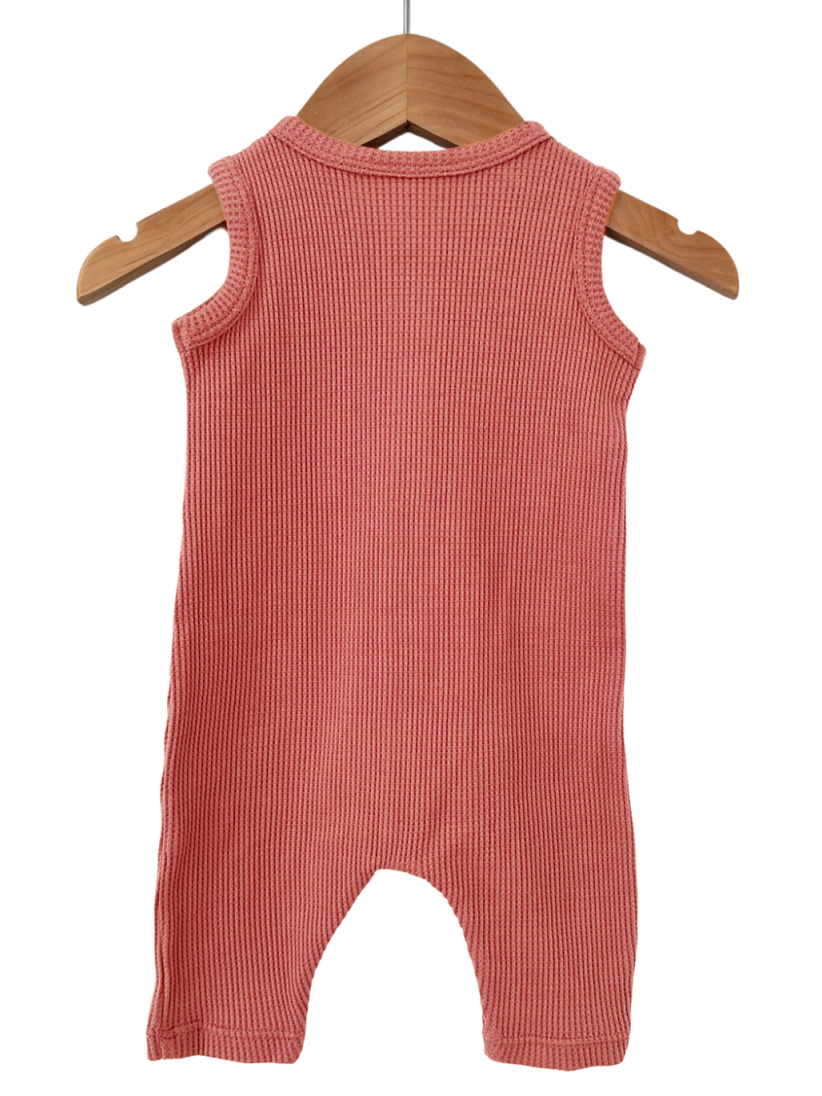 Back view of a sleeveless, ribbed pink baby romper hanging on a wooden hanger.