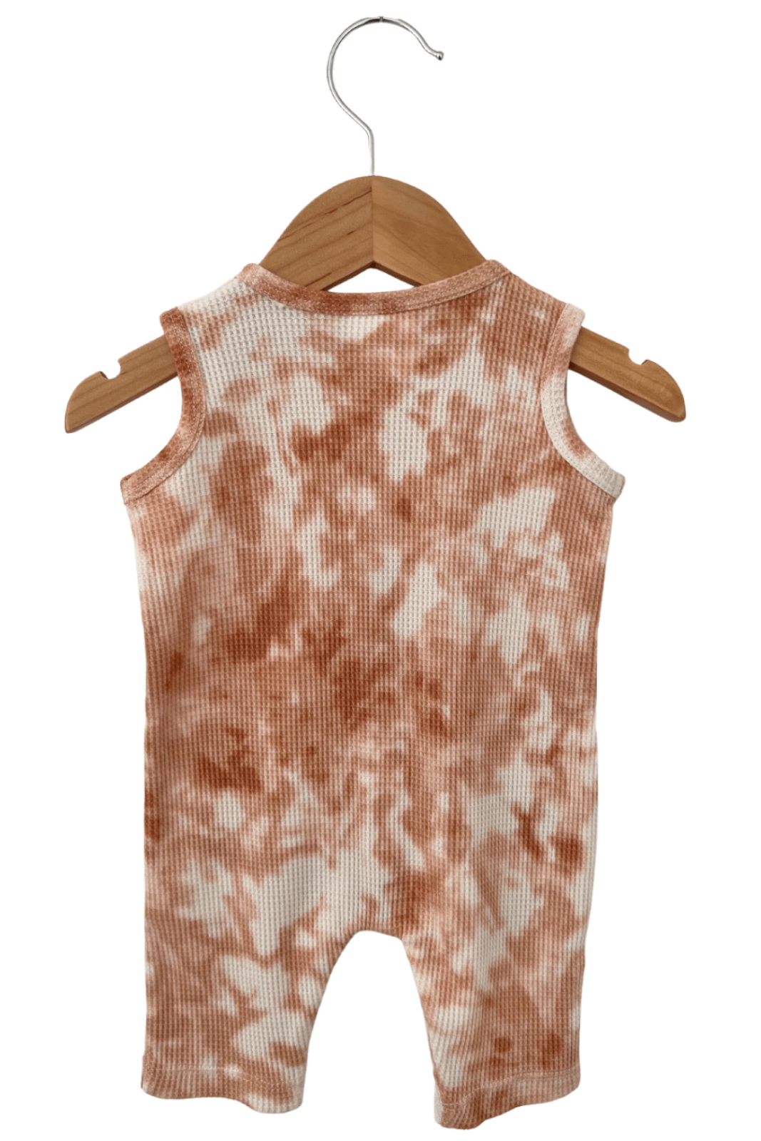 Back view of a sleeveless baby romper hanging on a wooden hanger, featuring a tie-dye pattern in peach and white.