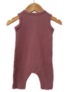 Back view of a ribbed, sleeveless infant romper in soft mauve, hanging on a wooden hanger.