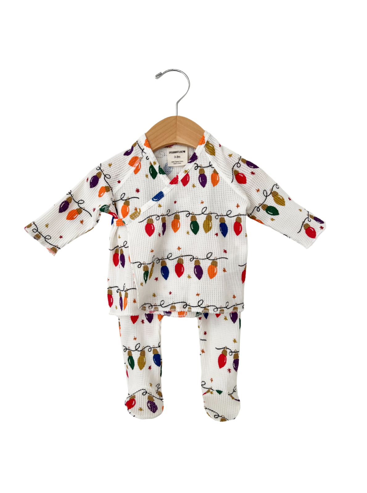 Holiday-themed baby outfit featuring colorful string lights on a white background, displayed on a wooden hanger.