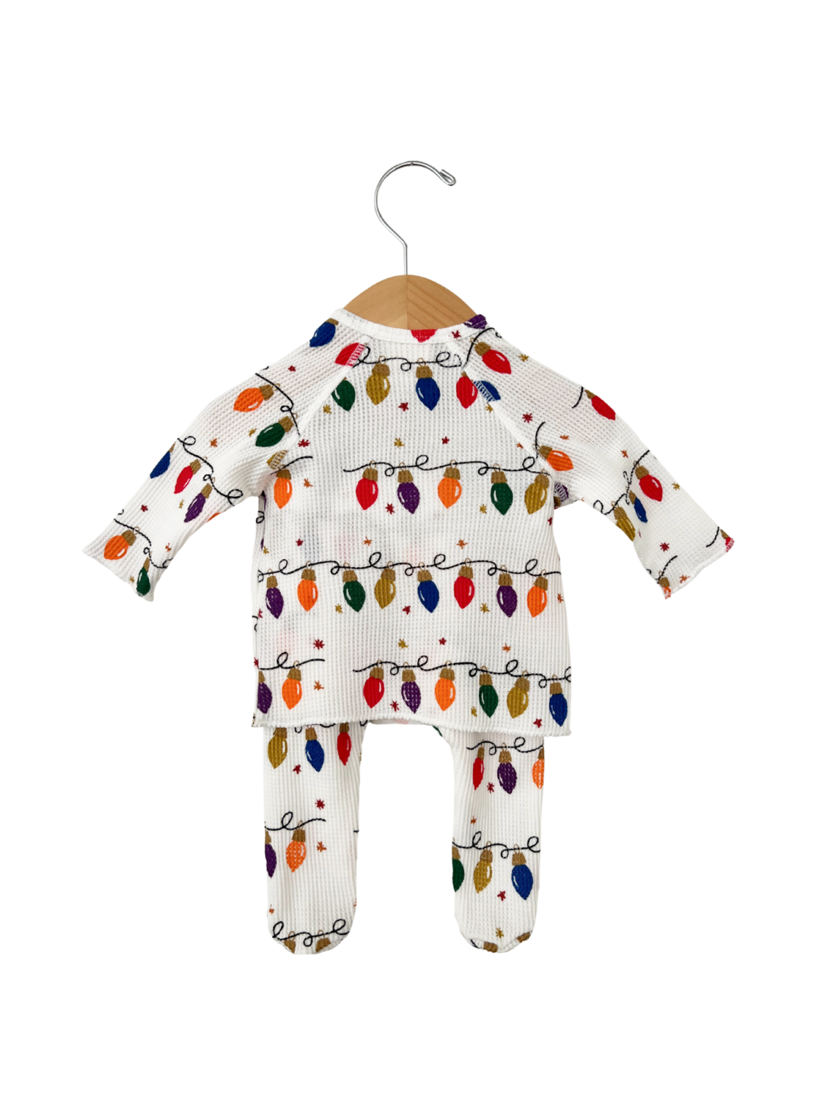 White children's outfit with colorful holiday lights, hanging on a wooden hanger.