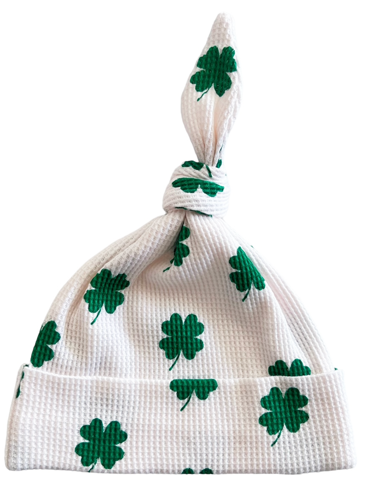 White knit hat adorned with green shamrocks, tied at the top for a playful look. Perfect for St. Patrick's Day.