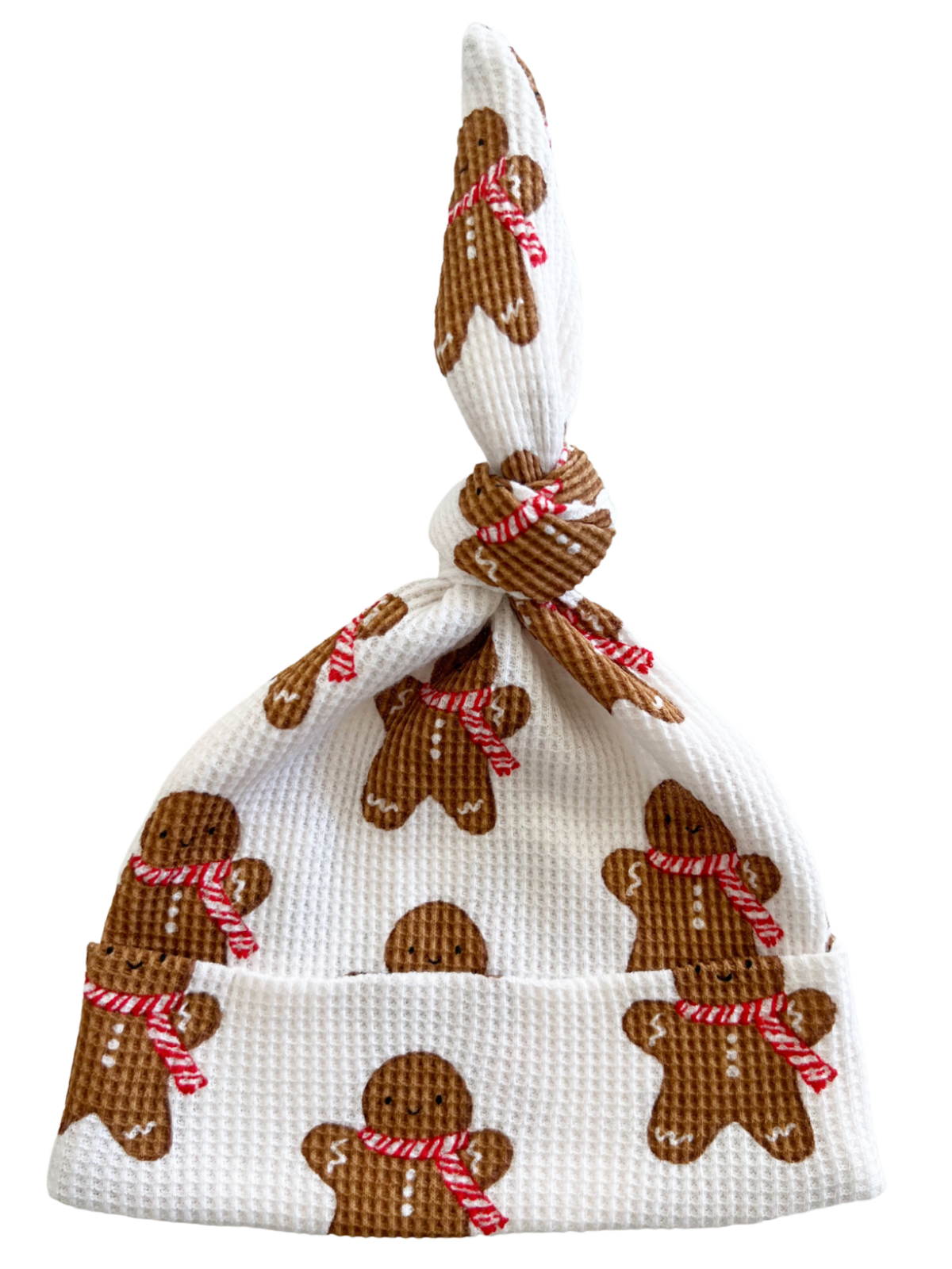 White baby hat with gingerbread man patterns and a knot at the top. Ideal for festive occasions.