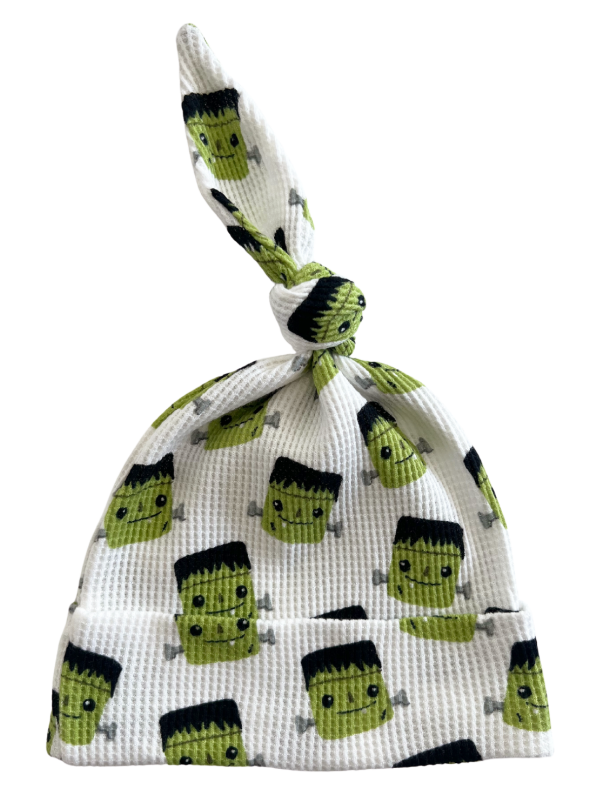 White baby hat featuring cute Frankenstein character patterns with a knotted top. Ideal for infants and playful occasions.