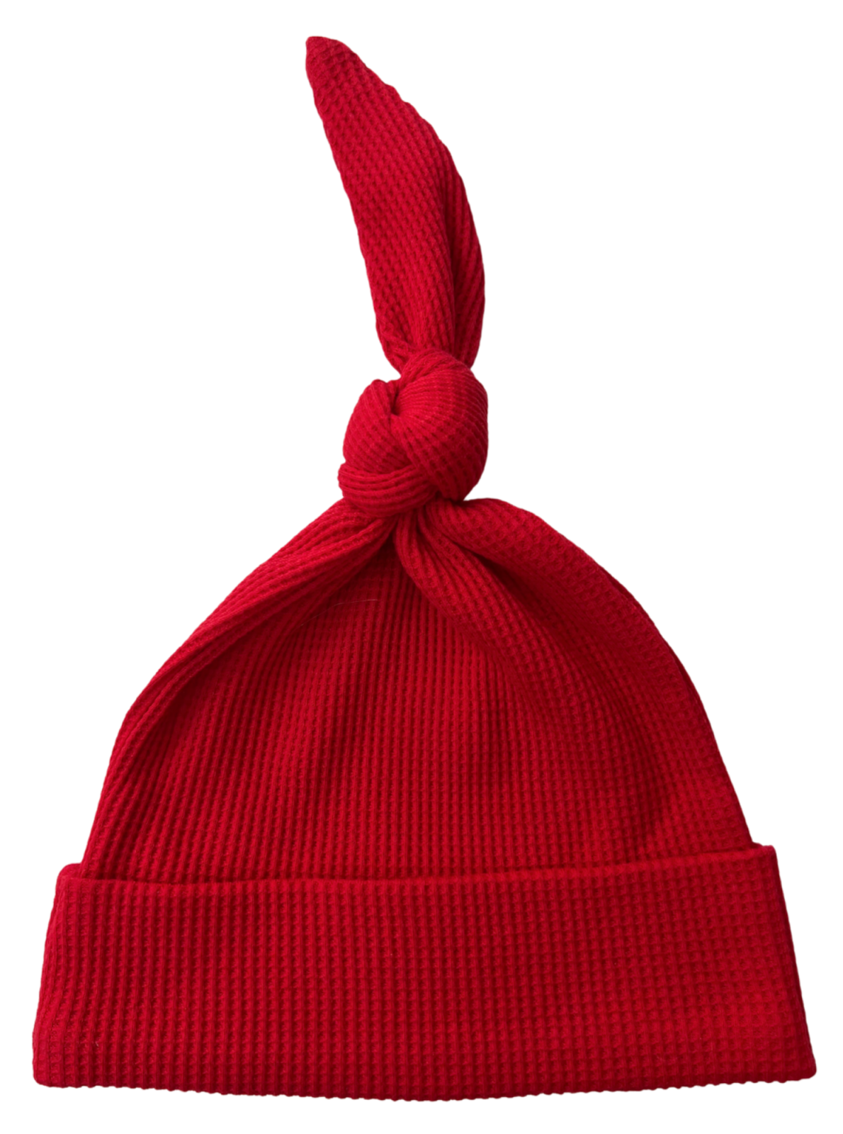 Red knit hat with a knot on top and a folded brim, designed for warmth and style.