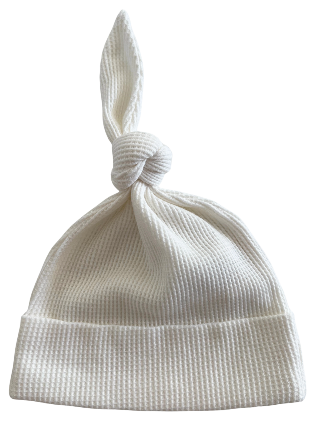 White knotted baby hat made from soft, textured fabric, suitable for newborns.