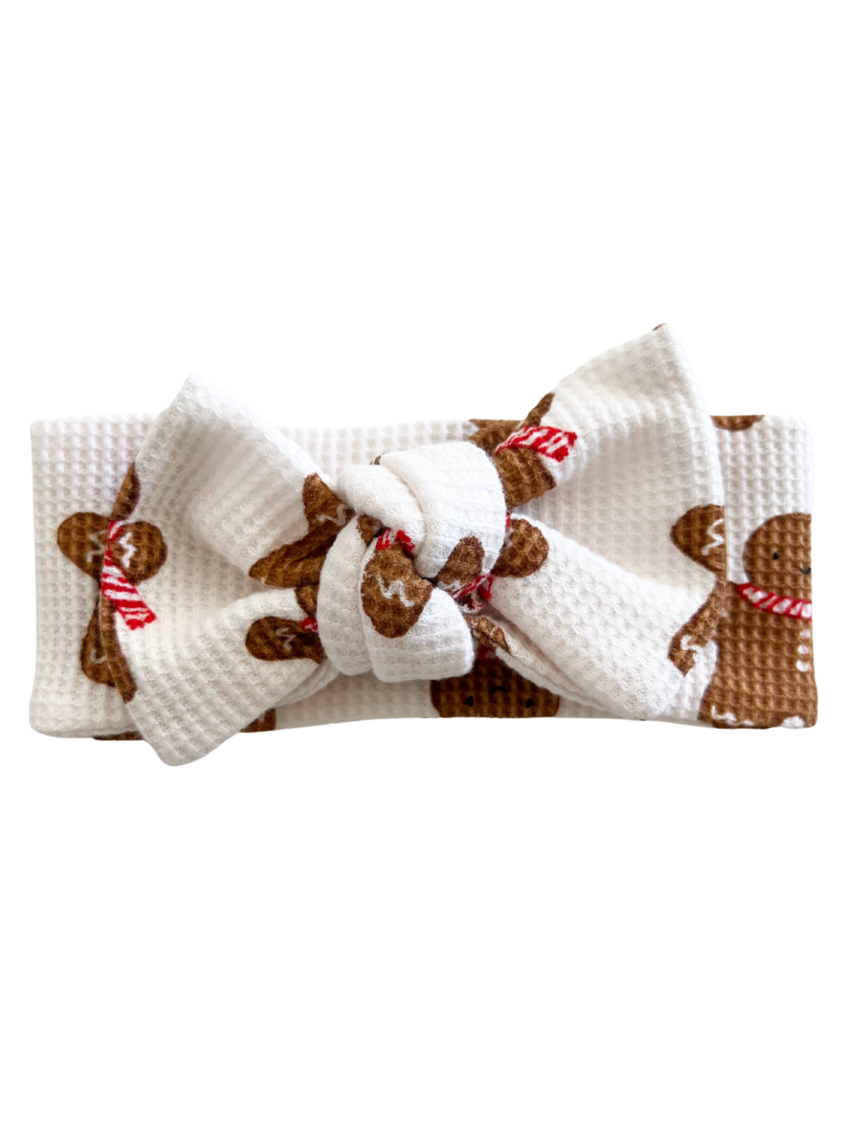 White hairband with a large bow featuring gingerbread men and candy canes pattern. Perfect for festive occasions.