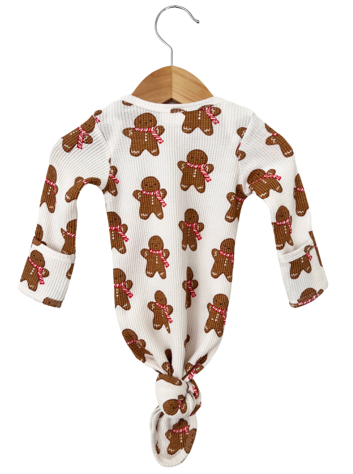 Brown gingerbread-themed onesie hanging on a wooden hanger against a white background.