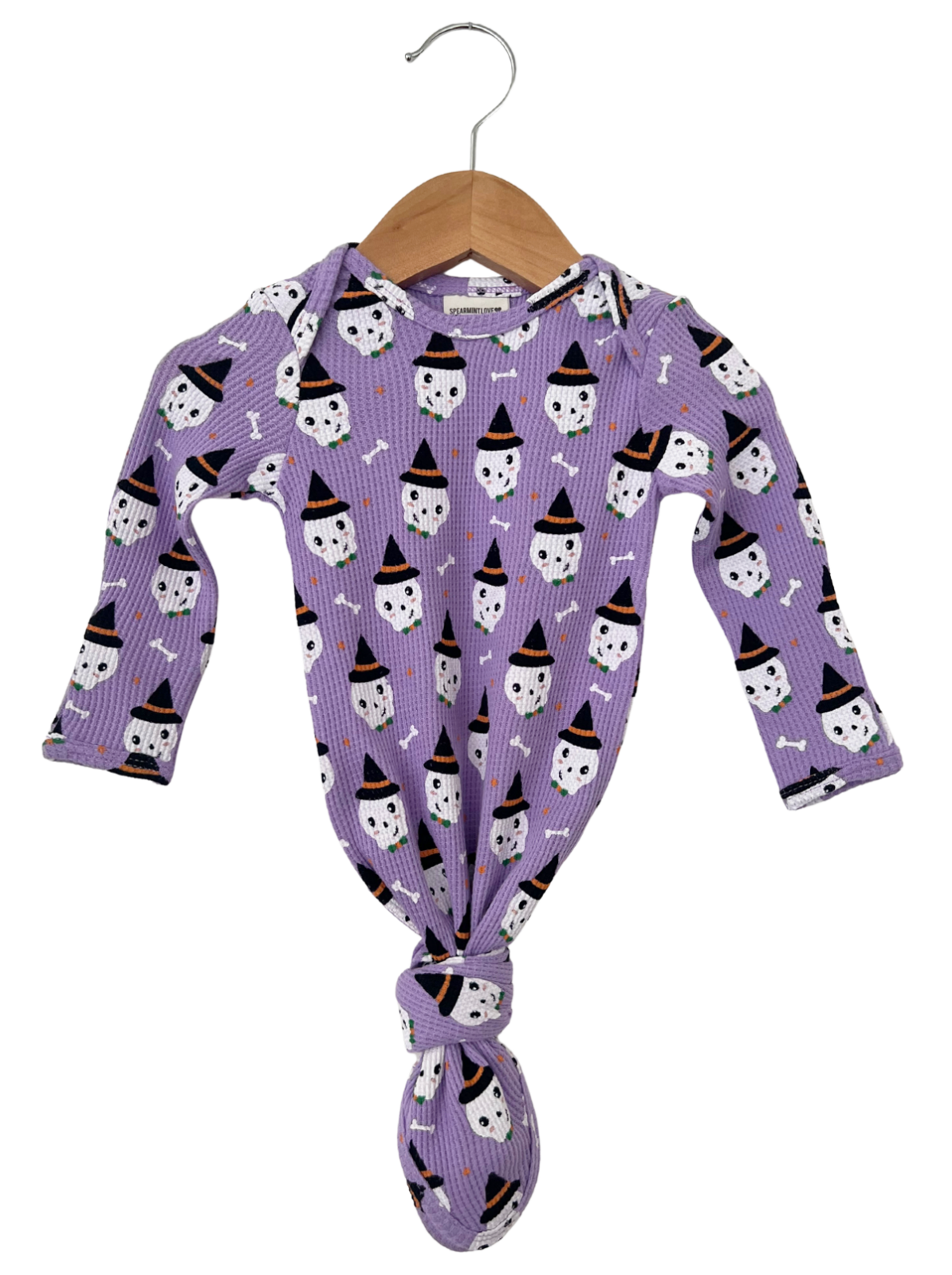 Purple long-sleeve onesie with ghost and witch hat pattern, hanging on a wooden hanger. Ideal for Halloween.