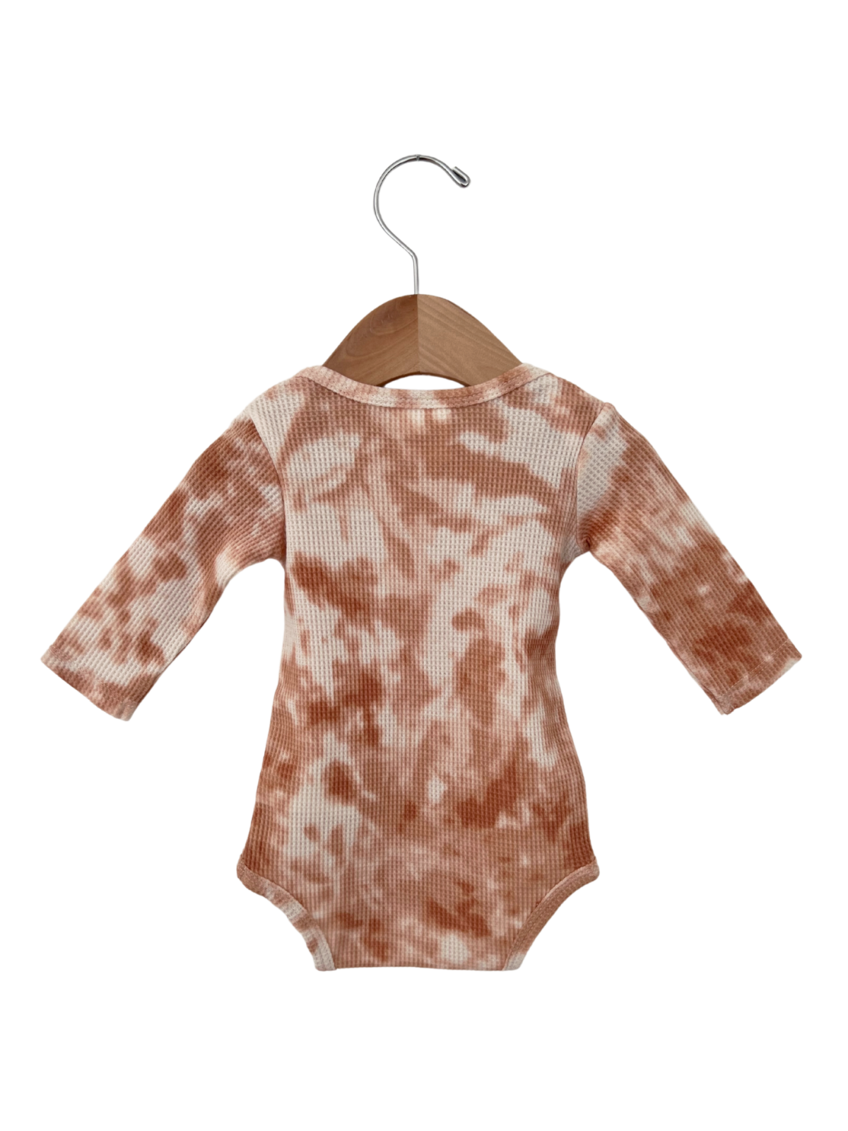 Brown tie-dye long-sleeve baby onesie hanging on a wooden hanger.