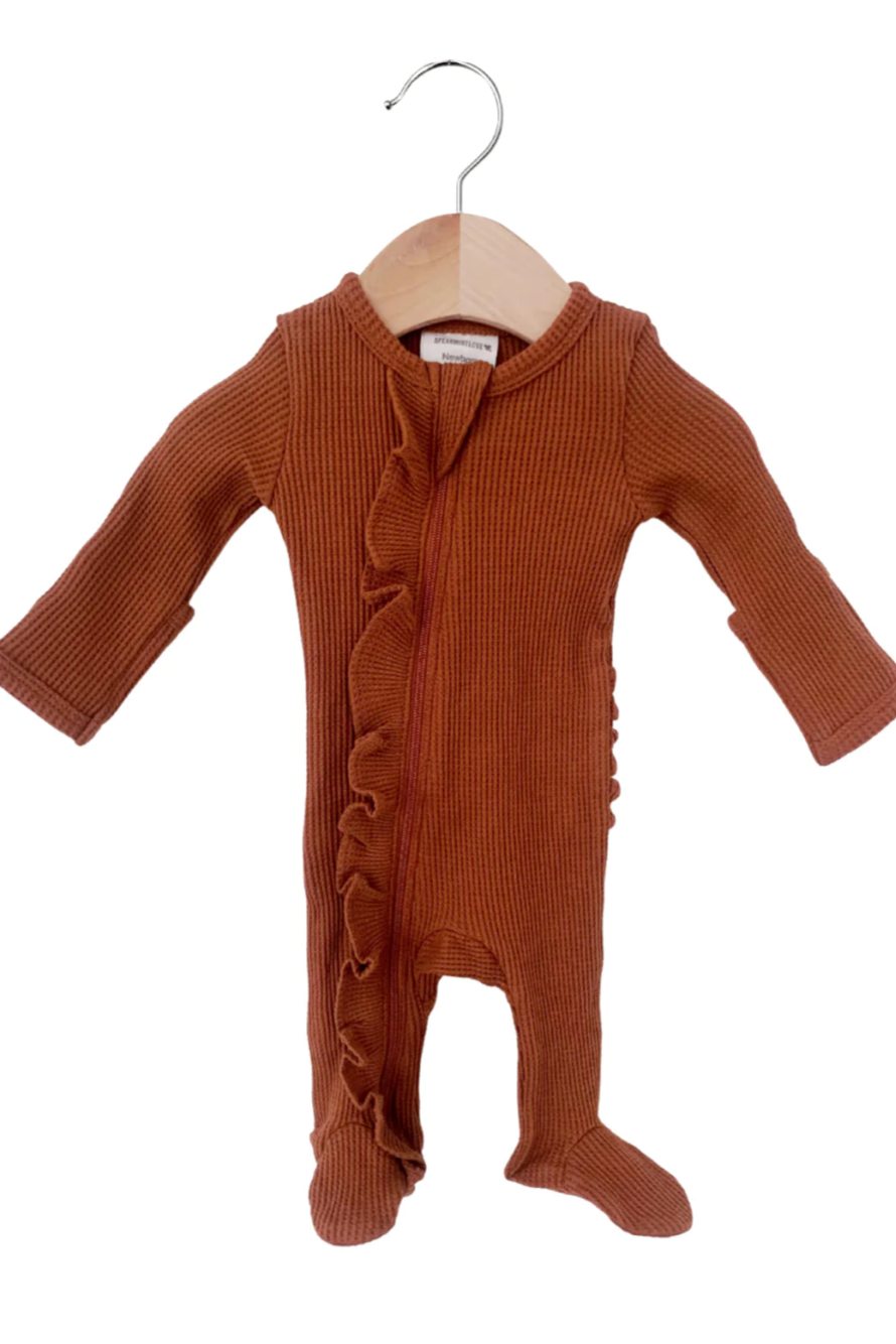 Brown ribbed baby onesie with ruffles, hanging on a wooden hanger against a white background.