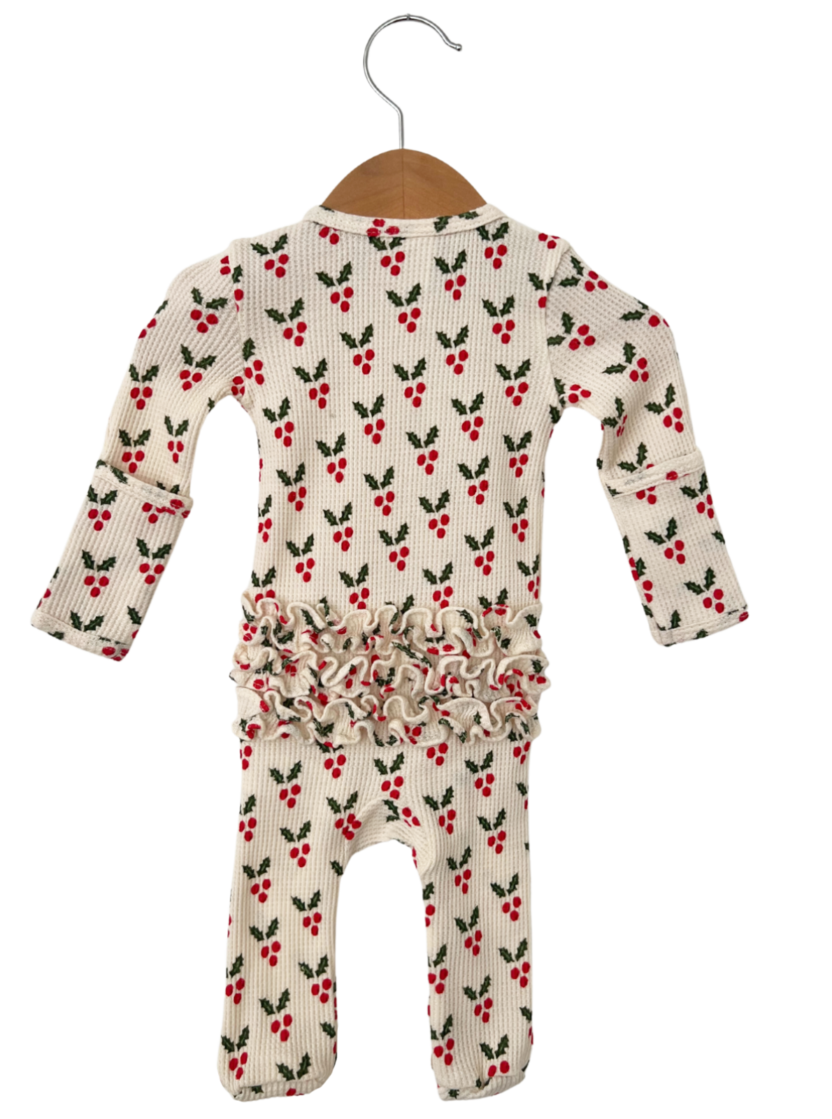White infant romper with red berry and green leaf print, featuring ruffled detailing at the waist.