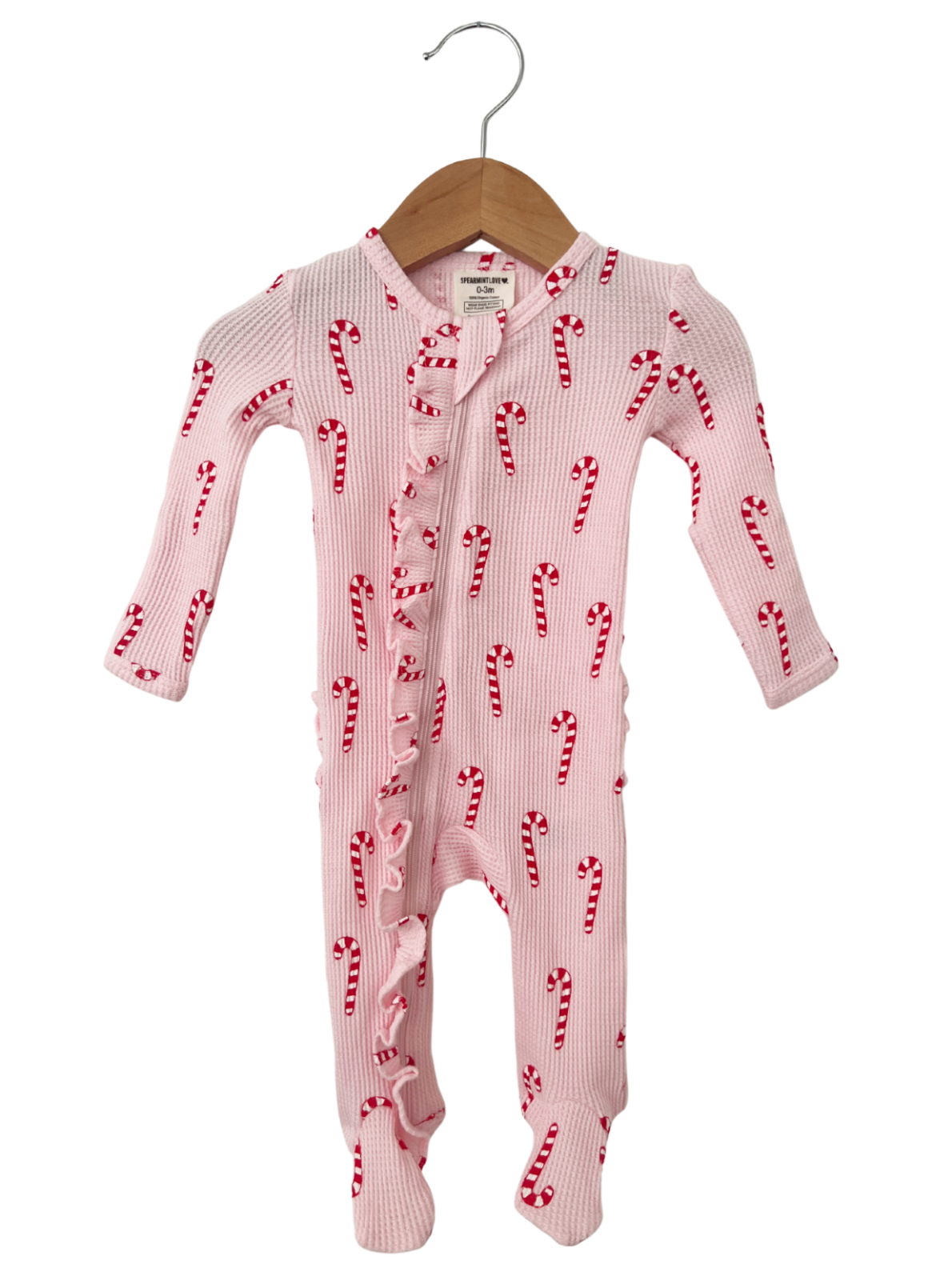 Pink baby onesie with candy cane pattern, featuring ruffles and long sleeves, hanging on a wooden hanger.