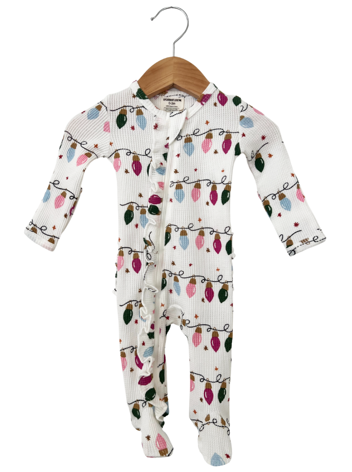 White baby onesie with festive light patterns, hanging on a wooden hanger.