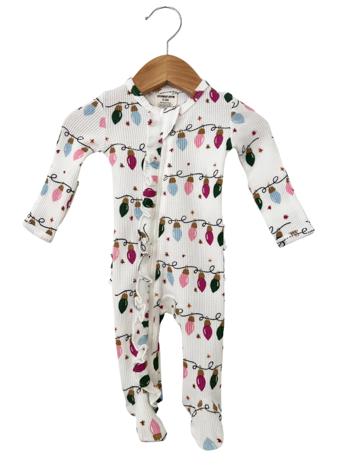 White baby onesie with festive light patterns, hanging on a wooden hanger.