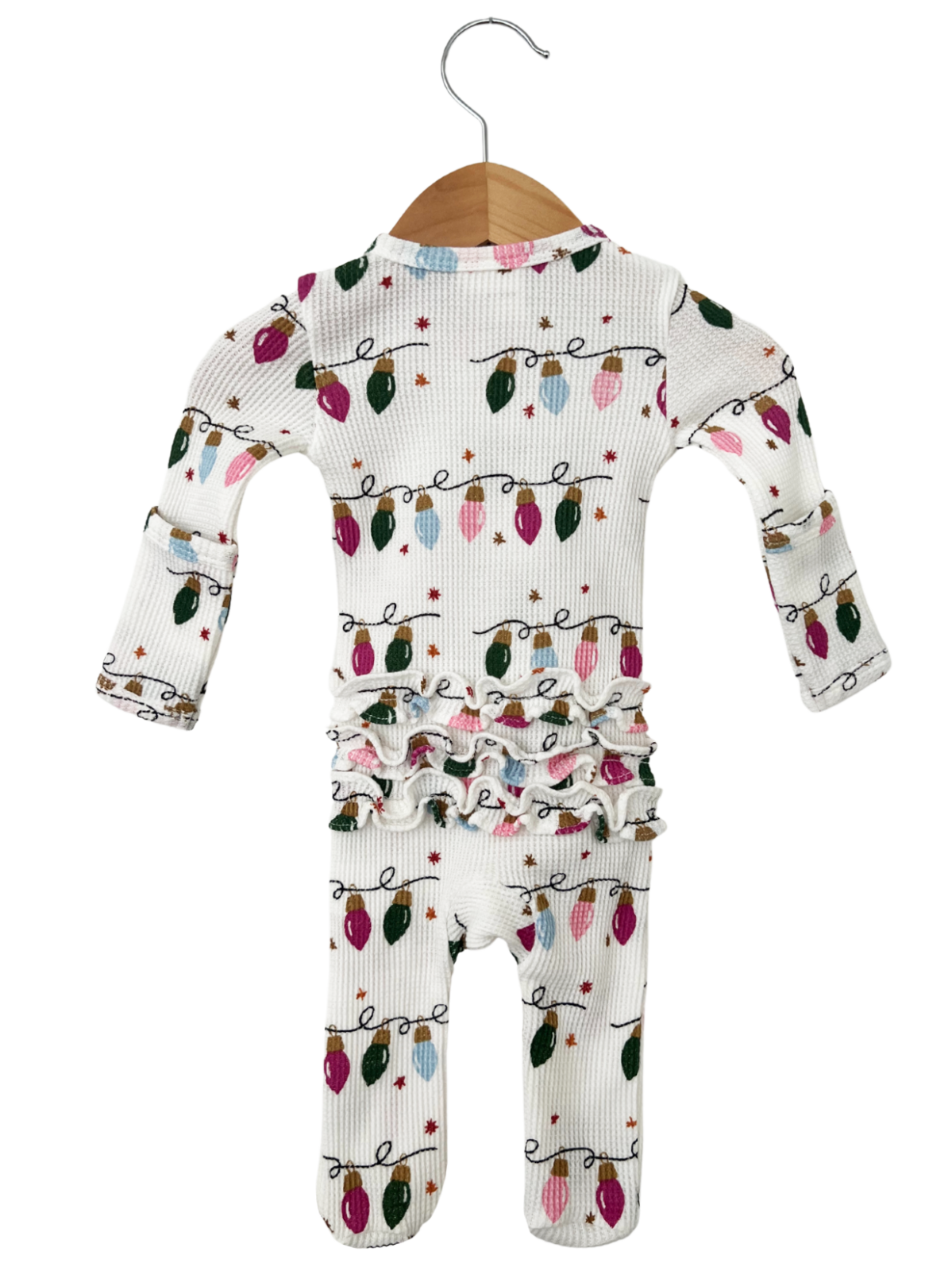 White pajamas with colorful Christmas lights pattern, featuring ruffled detailing around the waist.
