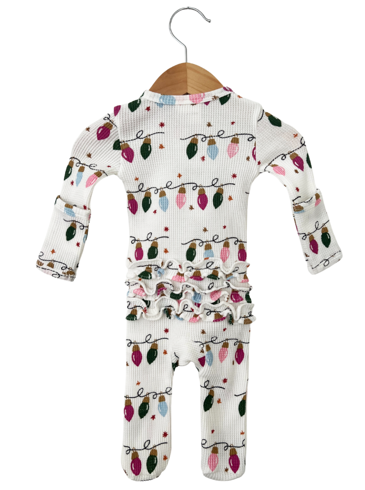 White pajamas with colorful Christmas lights pattern, featuring ruffled detailing around the waist.