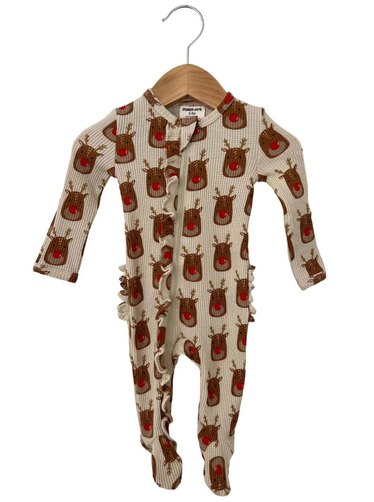 Christmas-themed baby onesie with reindeer pattern and ruffle details, hanging on a wooden hanger.
