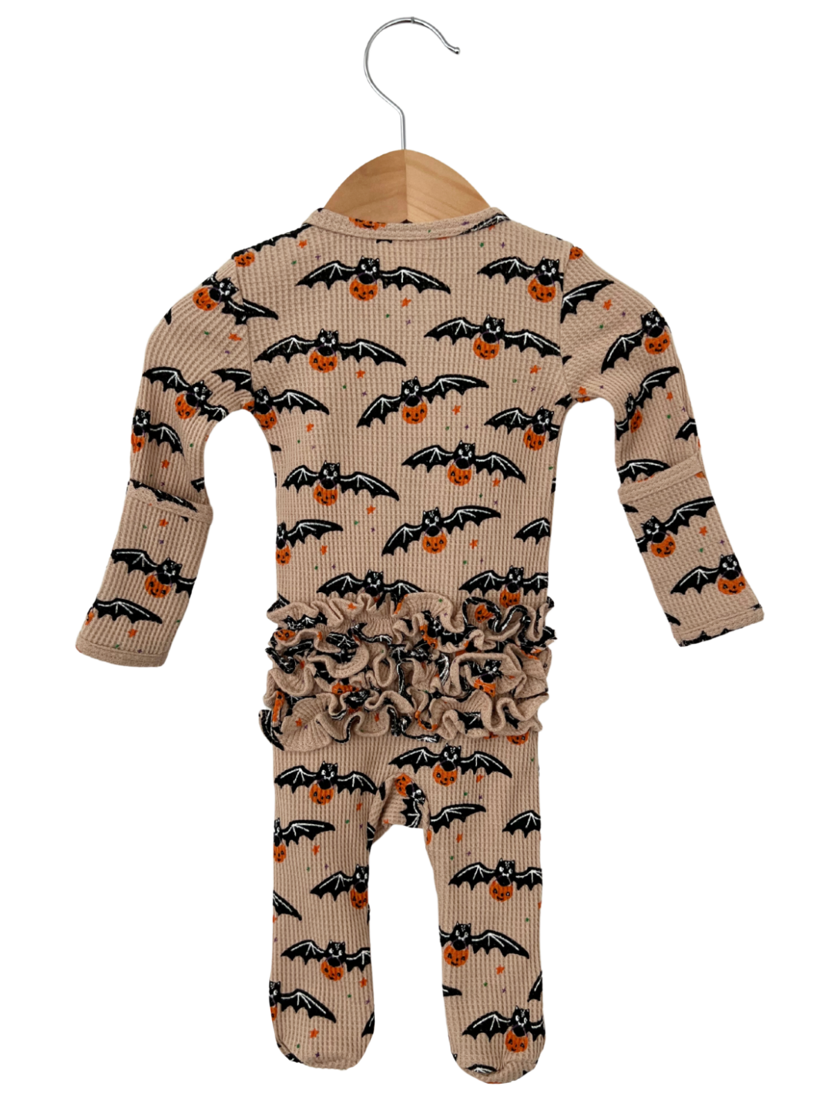 Beige baby romper with bat and pumpkin print, featuring ruffled waistband and hanging on a wooden hanger.