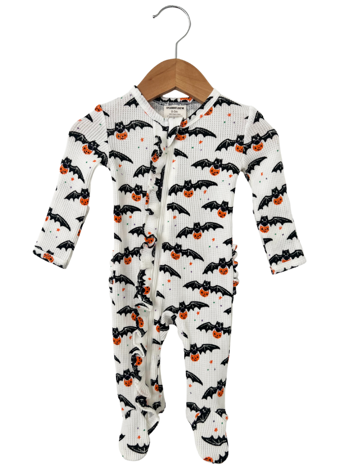 White bat-patterned onesie with orange pumpkins, hanging on a wooden hanger. Perfect for Halloween celebrations.