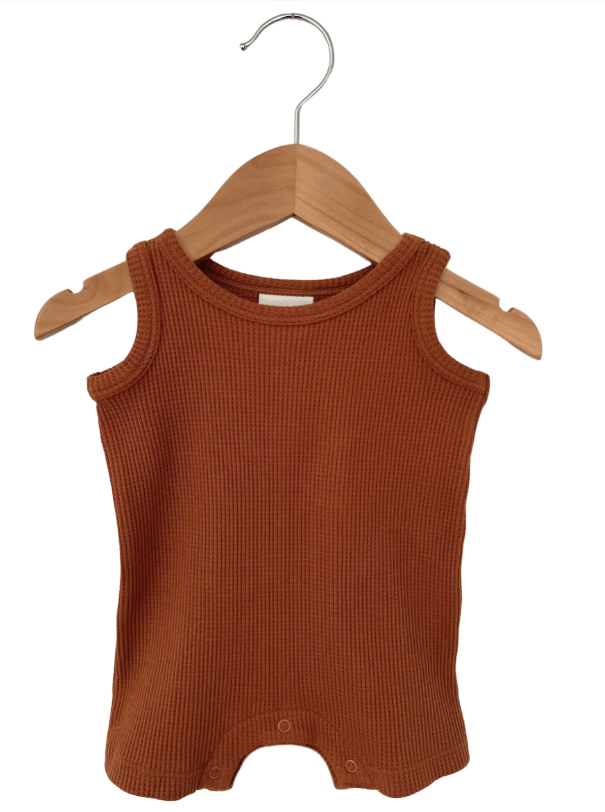 Rust-colored infant tank top with ribbed texture hanging on a wooden hanger.