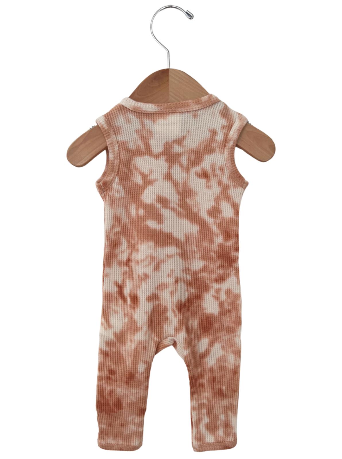 Peach tie-dye romper hanging on a wooden hanger against a white background.