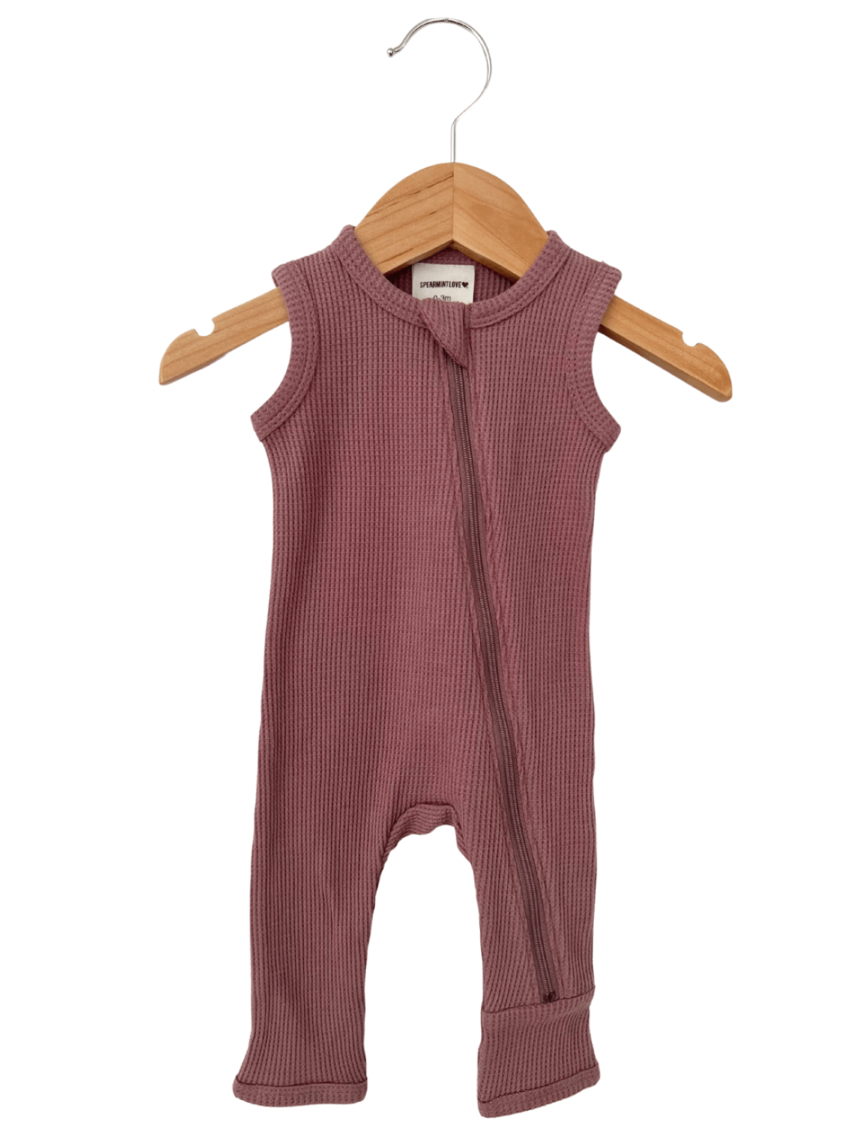 Ribbed sleeveless children's romper in mauve, hanging on a wooden hanger against a white background.