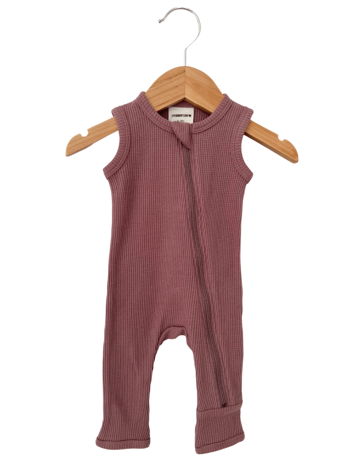 Ribbed sleeveless children's romper in mauve, hanging on a wooden hanger against a white background.