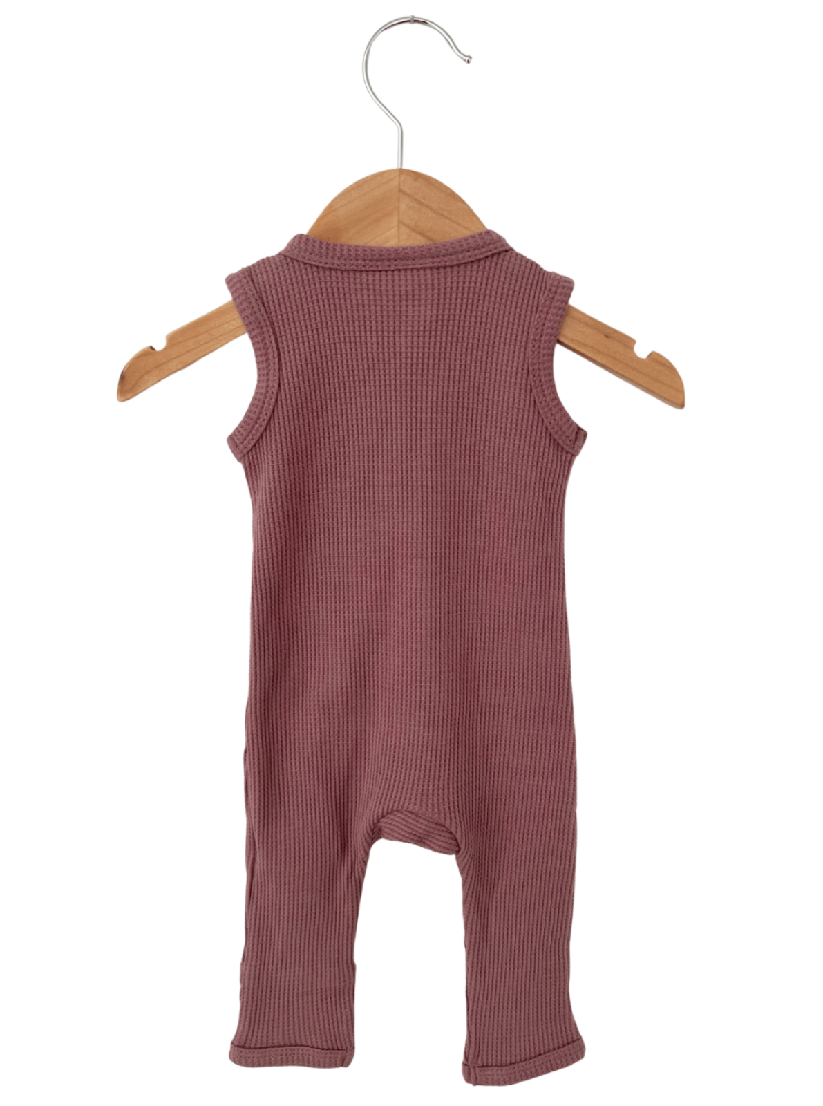 Back view of a sleeveless, ribbed baby onesie in mauve, hanging on a wooden hanger.
