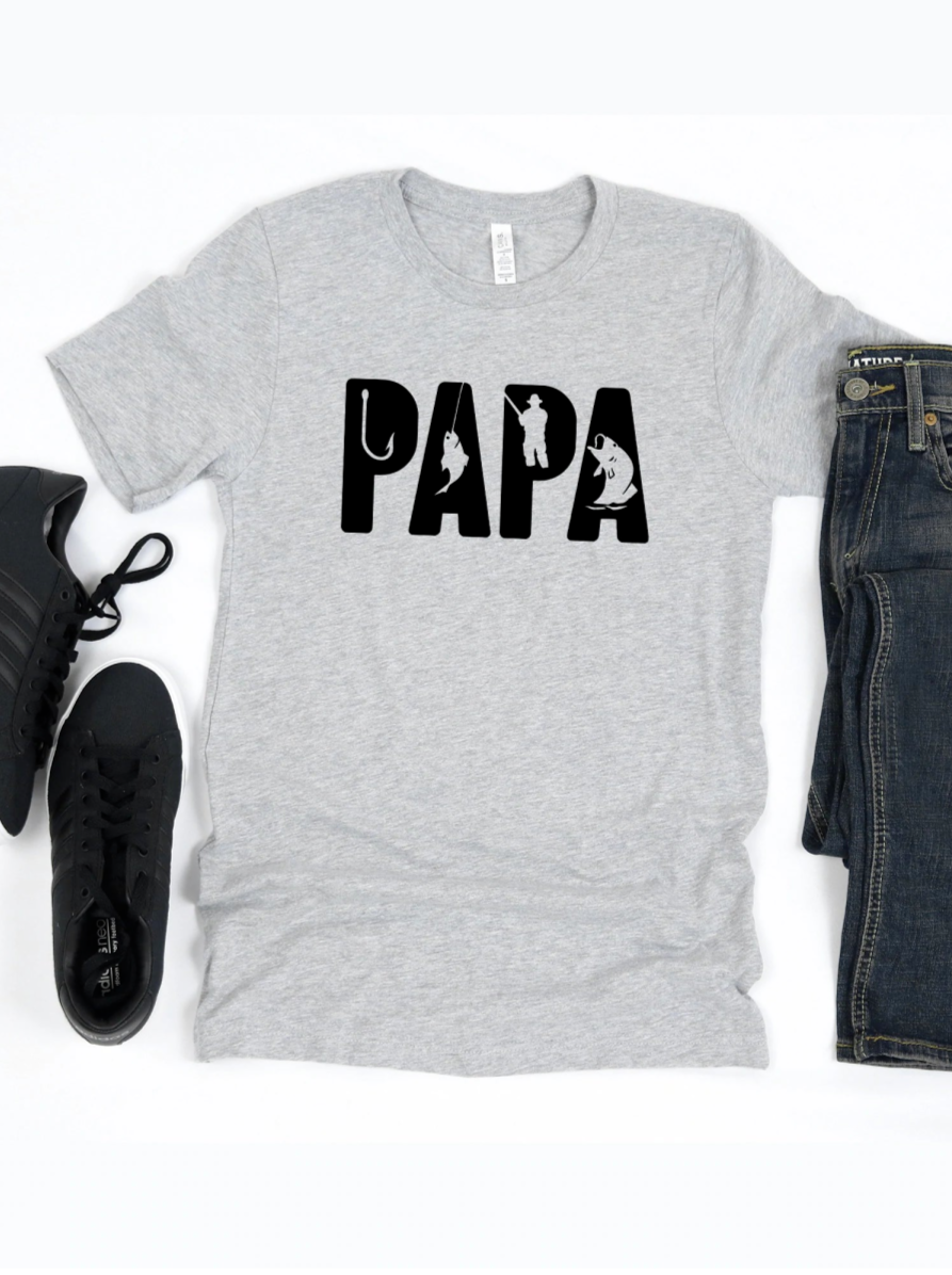Gray t-shirt with "PAPA" design, featuring fishing graphics, styled with black sneakers and denim jeans.
