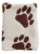 Cream-colored blanket with brown paw print patterns on a soft, textured surface.