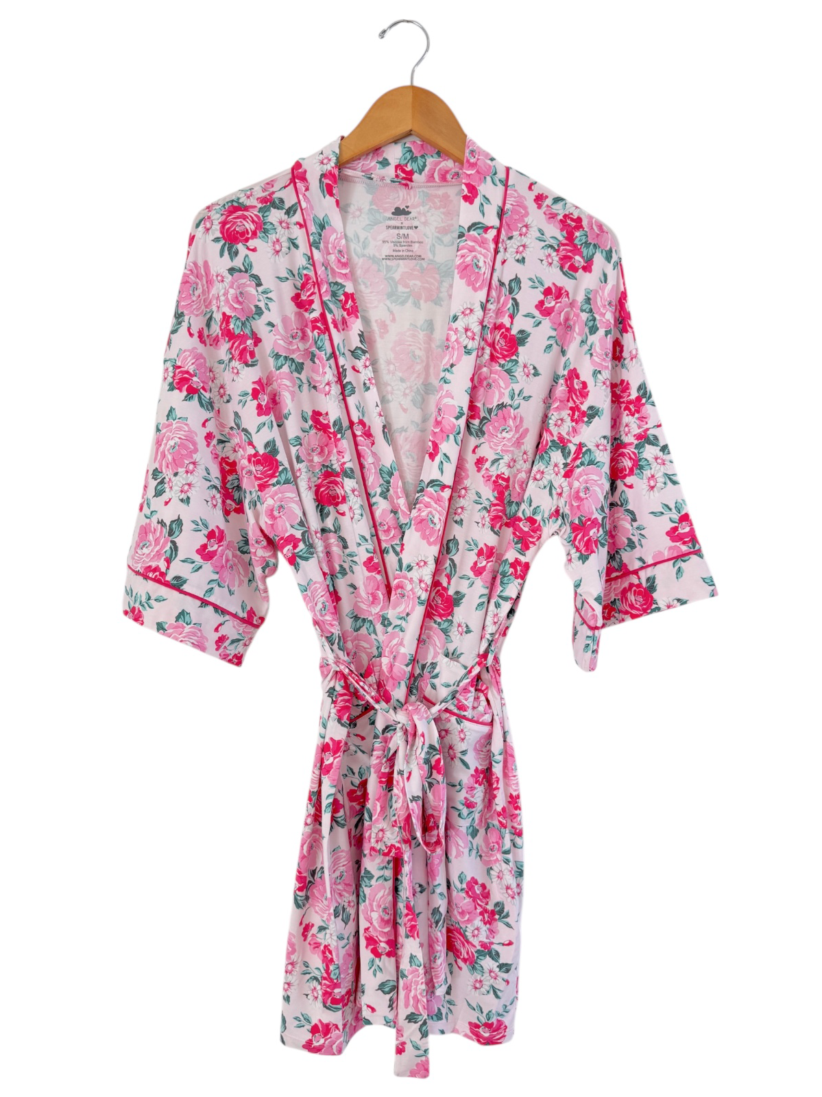 Floral pink robe with short sleeves and tie belt, displayed on a wooden hanger against a white background.