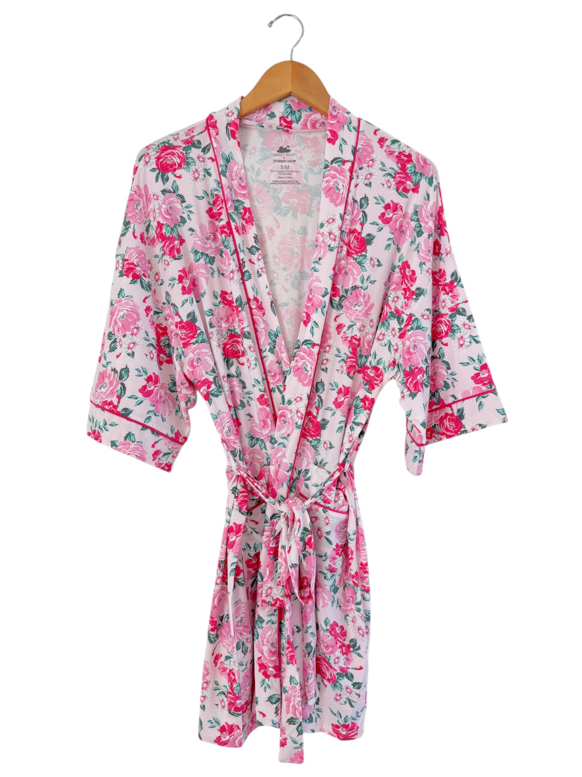 Floral pink robe with short sleeves and tie belt, displayed on a wooden hanger against a white background.