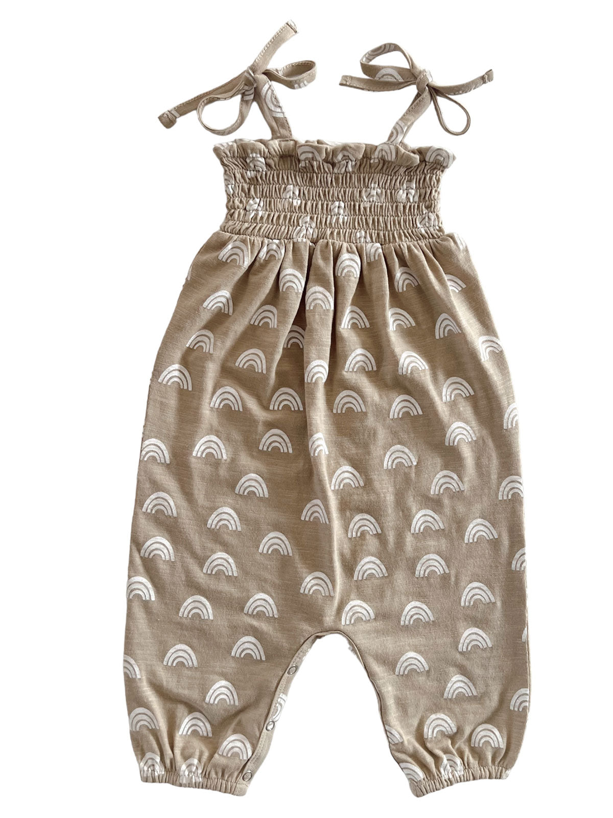 Tan romper with white rainbow patterns, featuring smocked bodice and adjustable tie straps, ideal for casual wear.