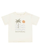 Light cream t-shirt with palm tree graphic, waves, sun, and the word "Santorini" printed below.