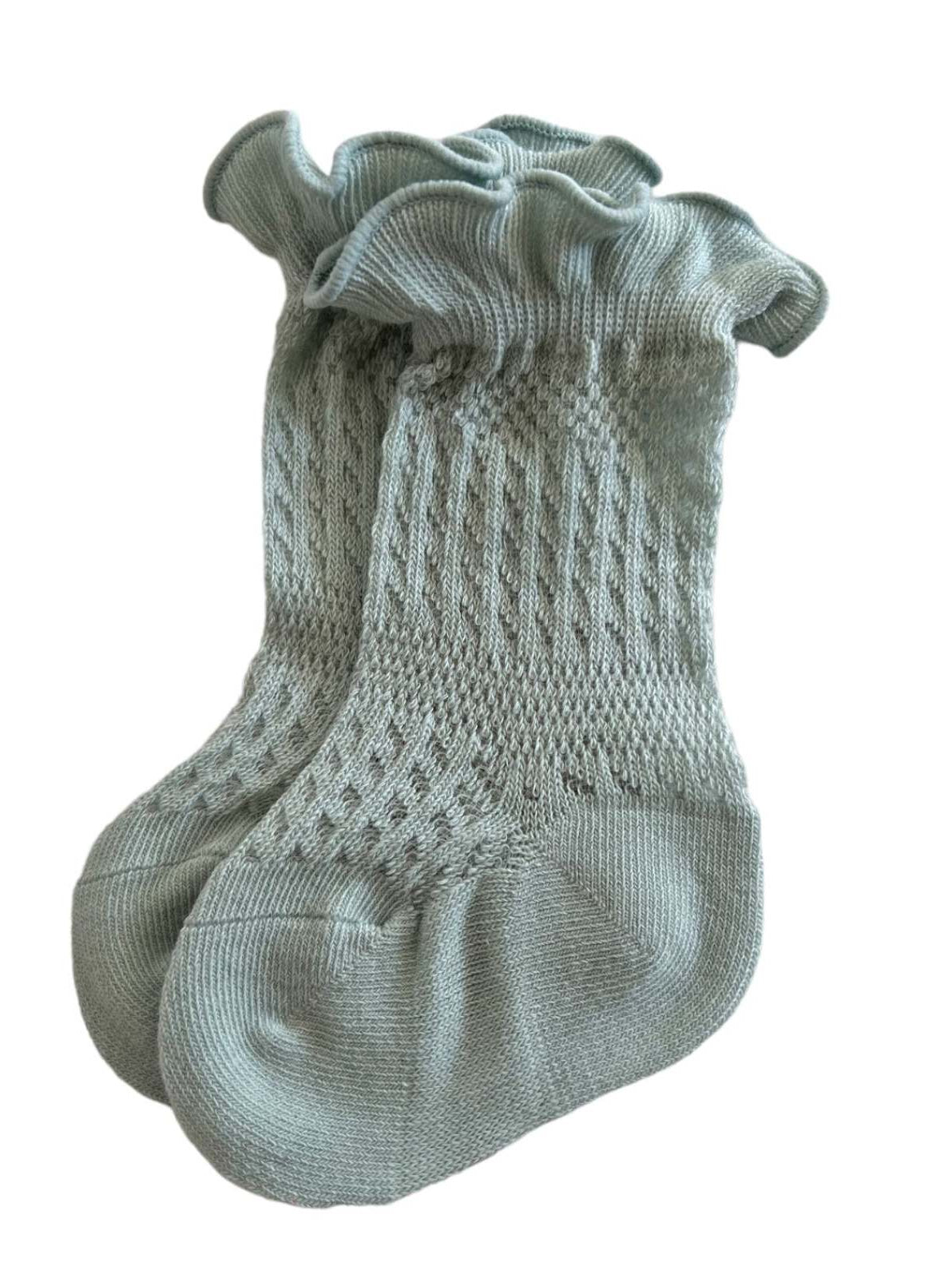 Light green knitted socks with a ruffled cuff and textured pattern. Ideal for stylish comfort.
