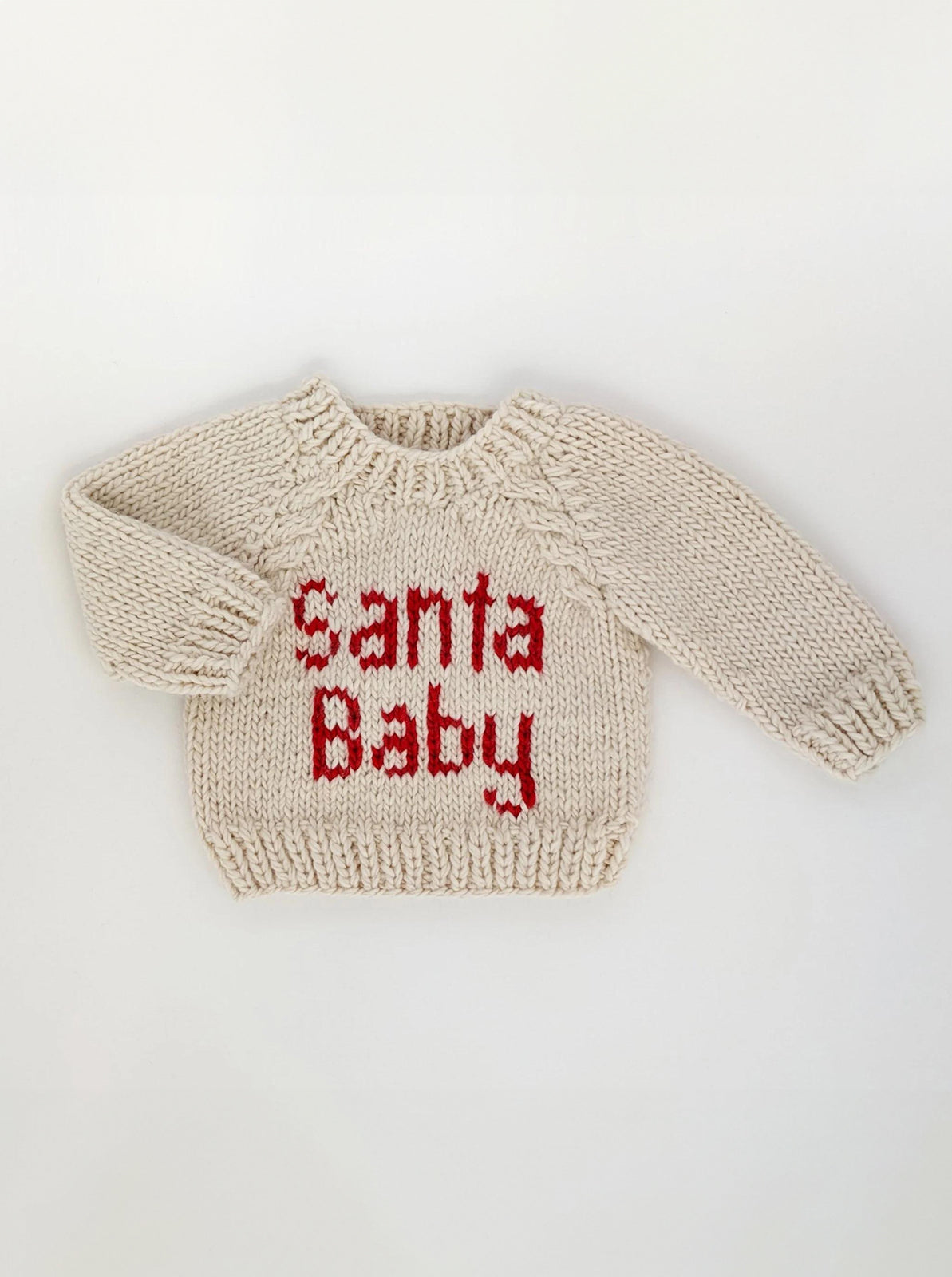 Cream-colored knitted sweater with the text "Santa Baby" in red letters.