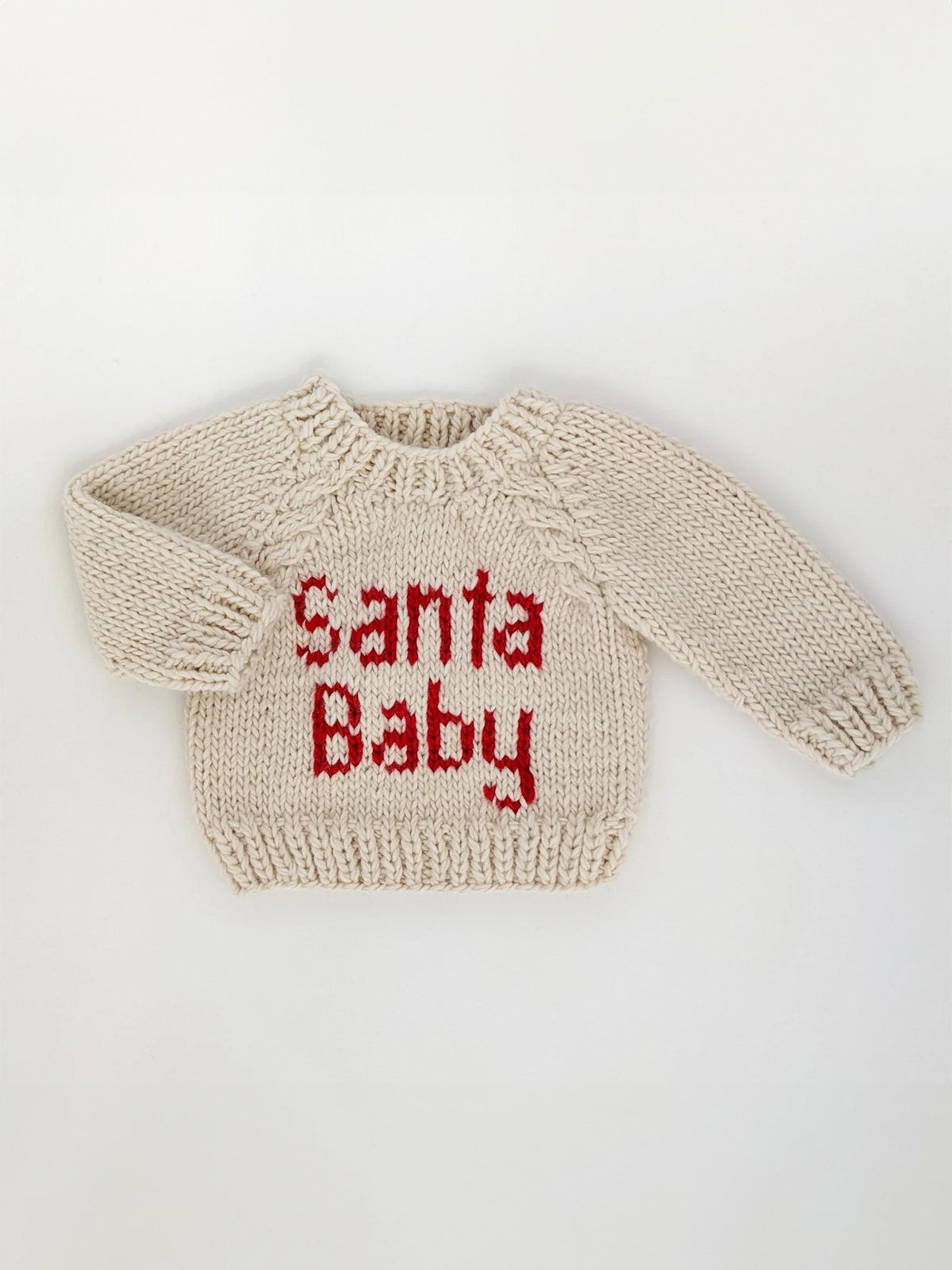 Cream-colored knitted sweater with the text "Santa Baby" in red letters.