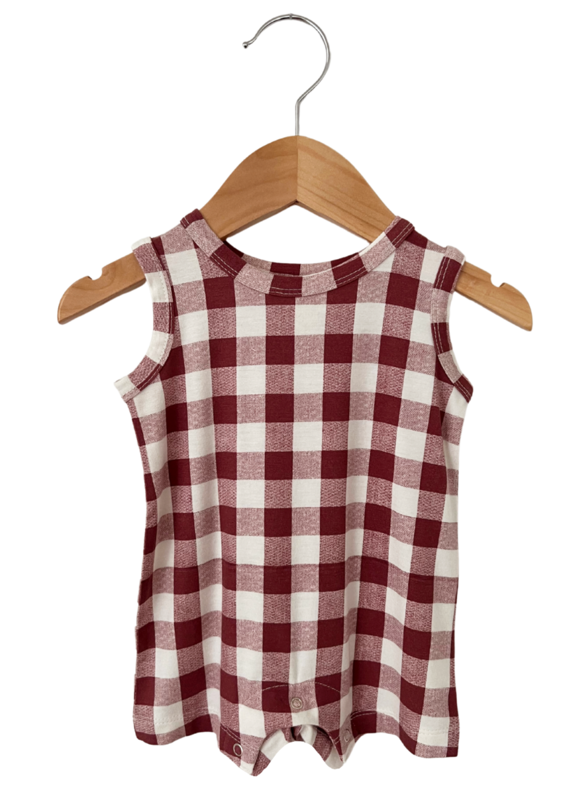 Red and white checkered baby romper hanging on a wooden hanger.