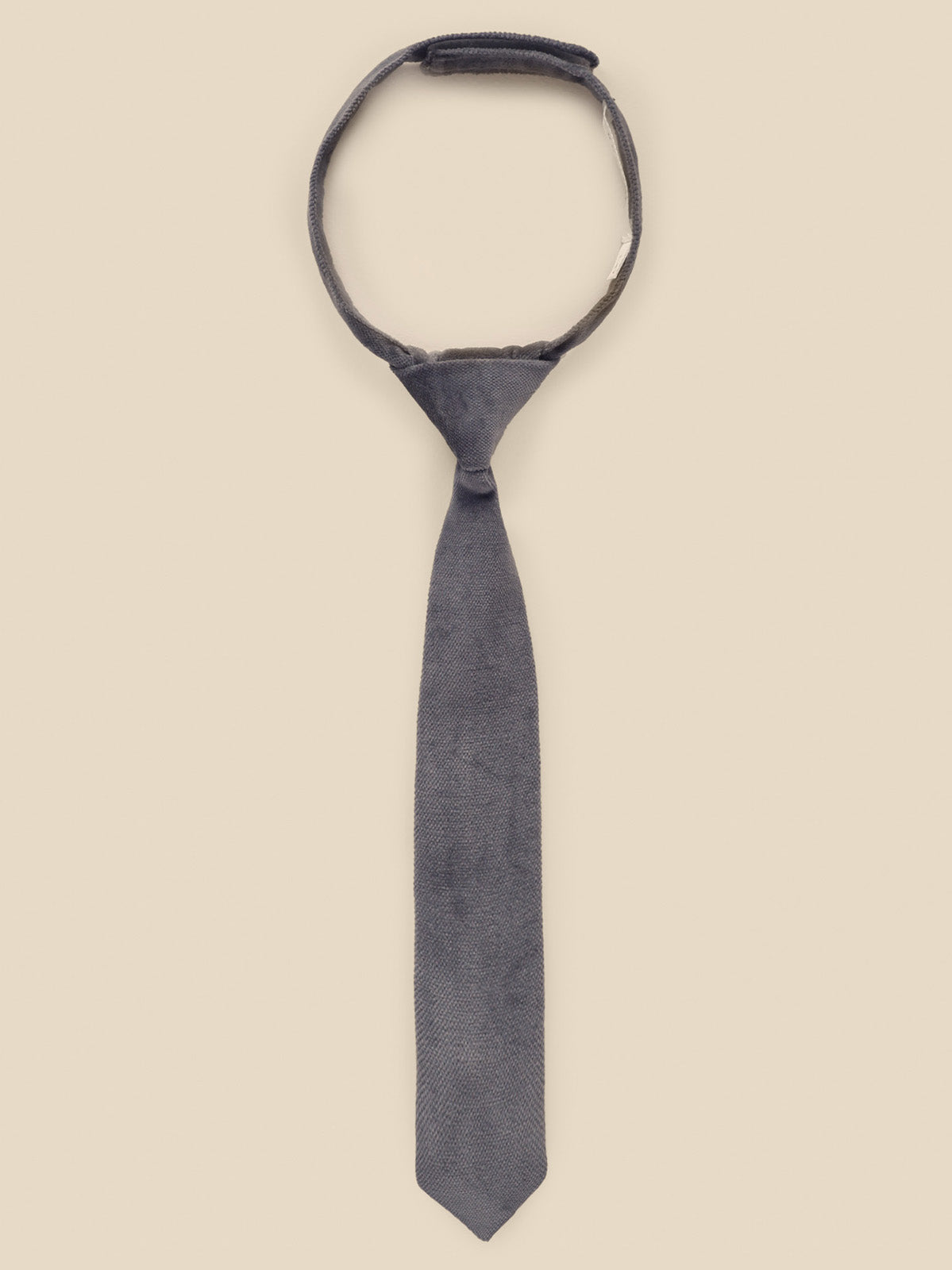 Gray tie displayed against a light beige background, showcasing a sleek design and classic style.