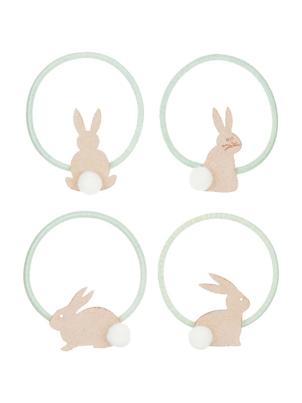 Set of four decorative bunny napkin rings in light pastel colors with pom-pom tails.