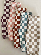 Five pairs of stylish checkered pants in various colors displayed against a light background.