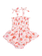 Pink baby romper with strawberry print and a flared skirt, featuring tie straps and smocked bodice.