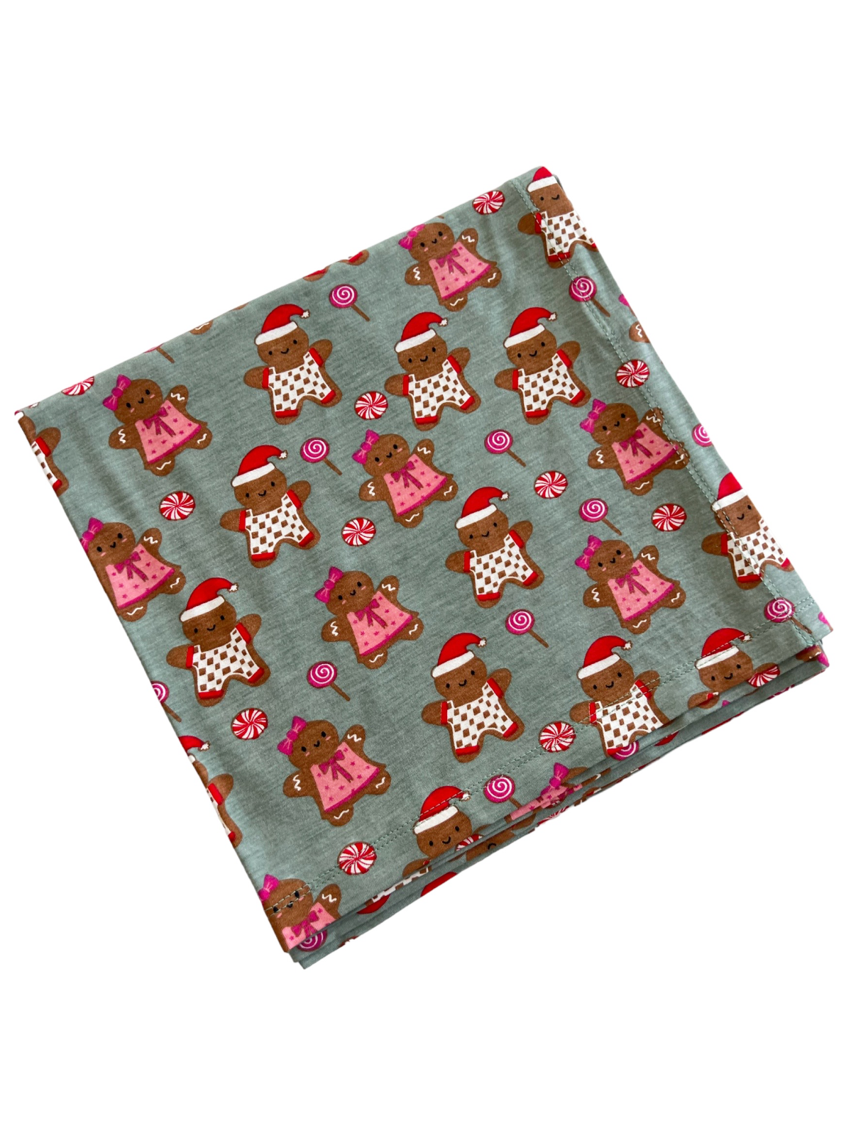 Gingerbread pattern fabric featuring festive candies and gingerbread characters wearing Santa hats.
